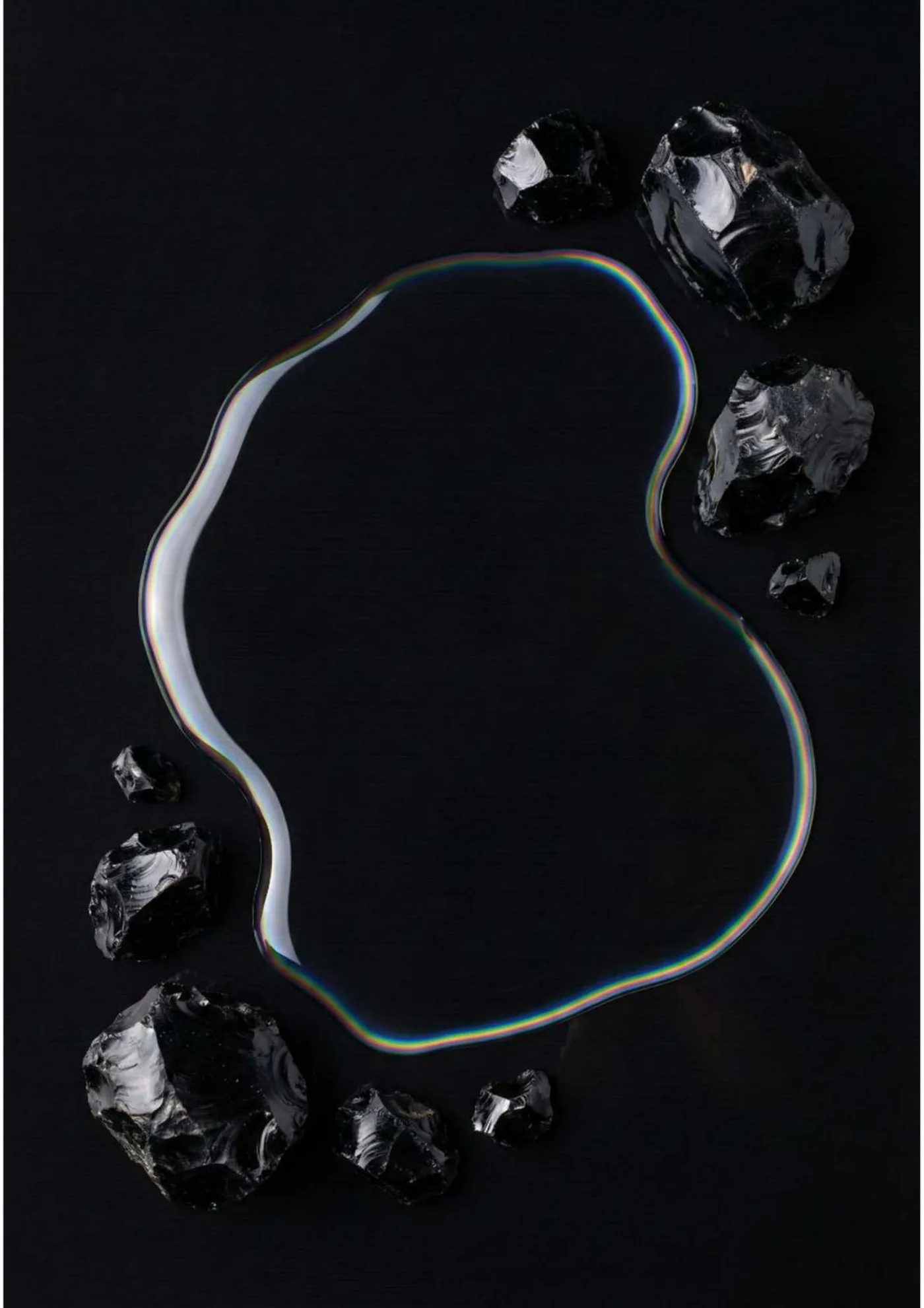 Pagina 2. Apertura fotografica su fondo nero: una composizione di materia lucida disegna una forma circolare.
