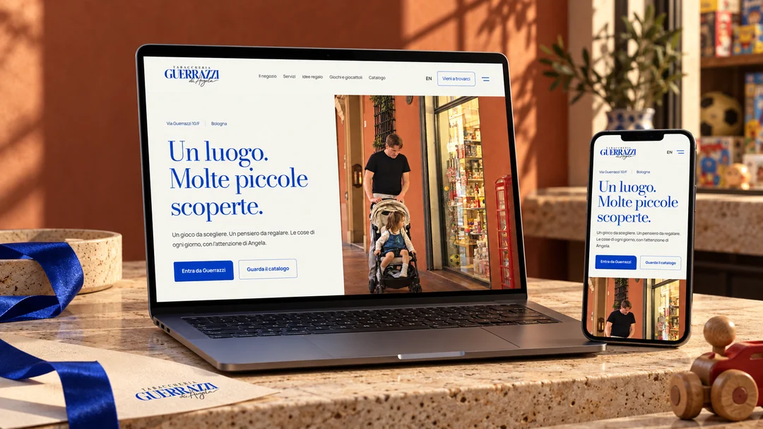 Il sito Guerrazzi di Angela presentato su laptop e smartphone, tra pietra, carta e dettagli del negozio. Mockup editoriale AI.